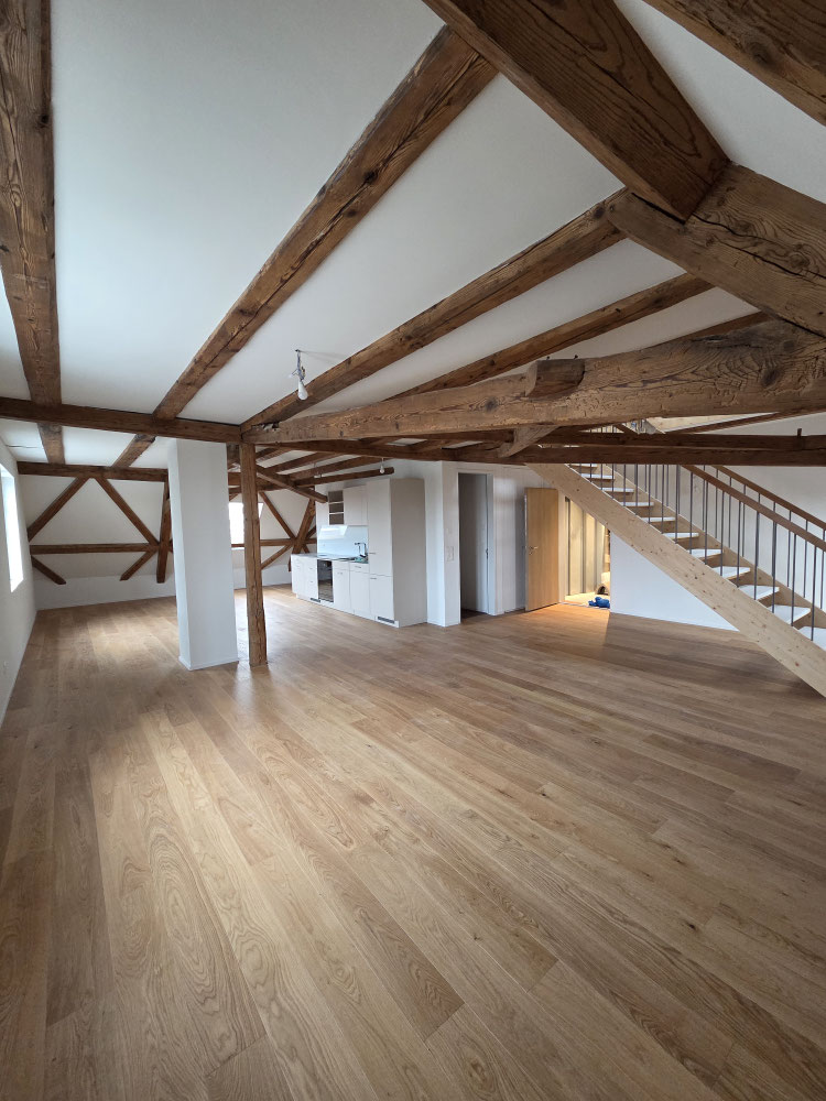 Renoviertes Dachgeschoss mit sichtbaren Holzbalken